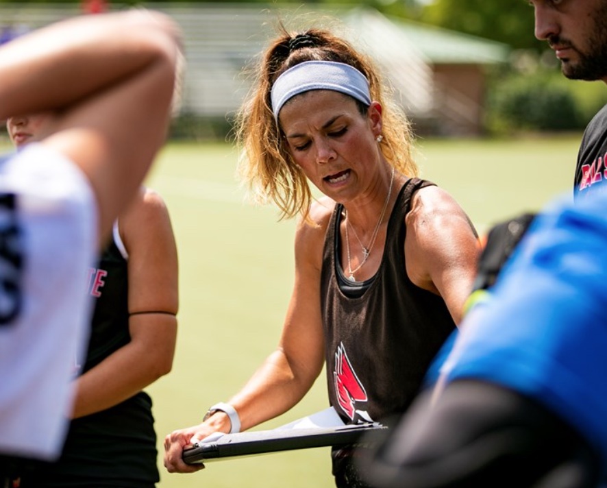 Stephanie Bernthal speaking to field hockey players with a whiteboard