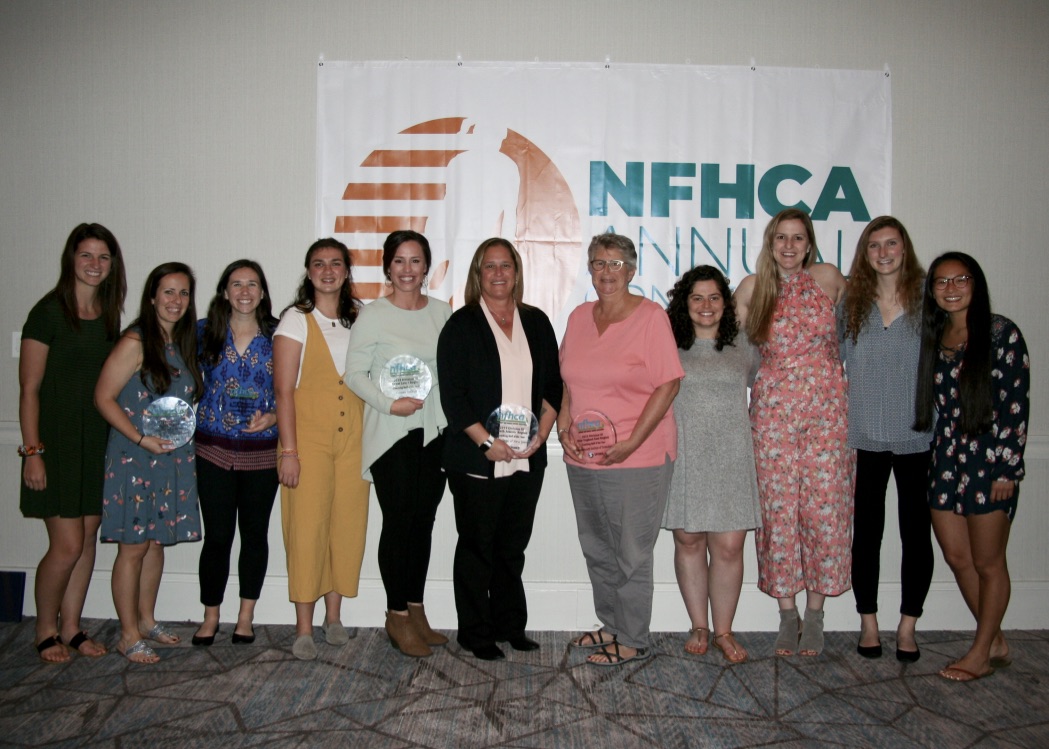 photo of older and younger women smiling while holding nfhca trophies